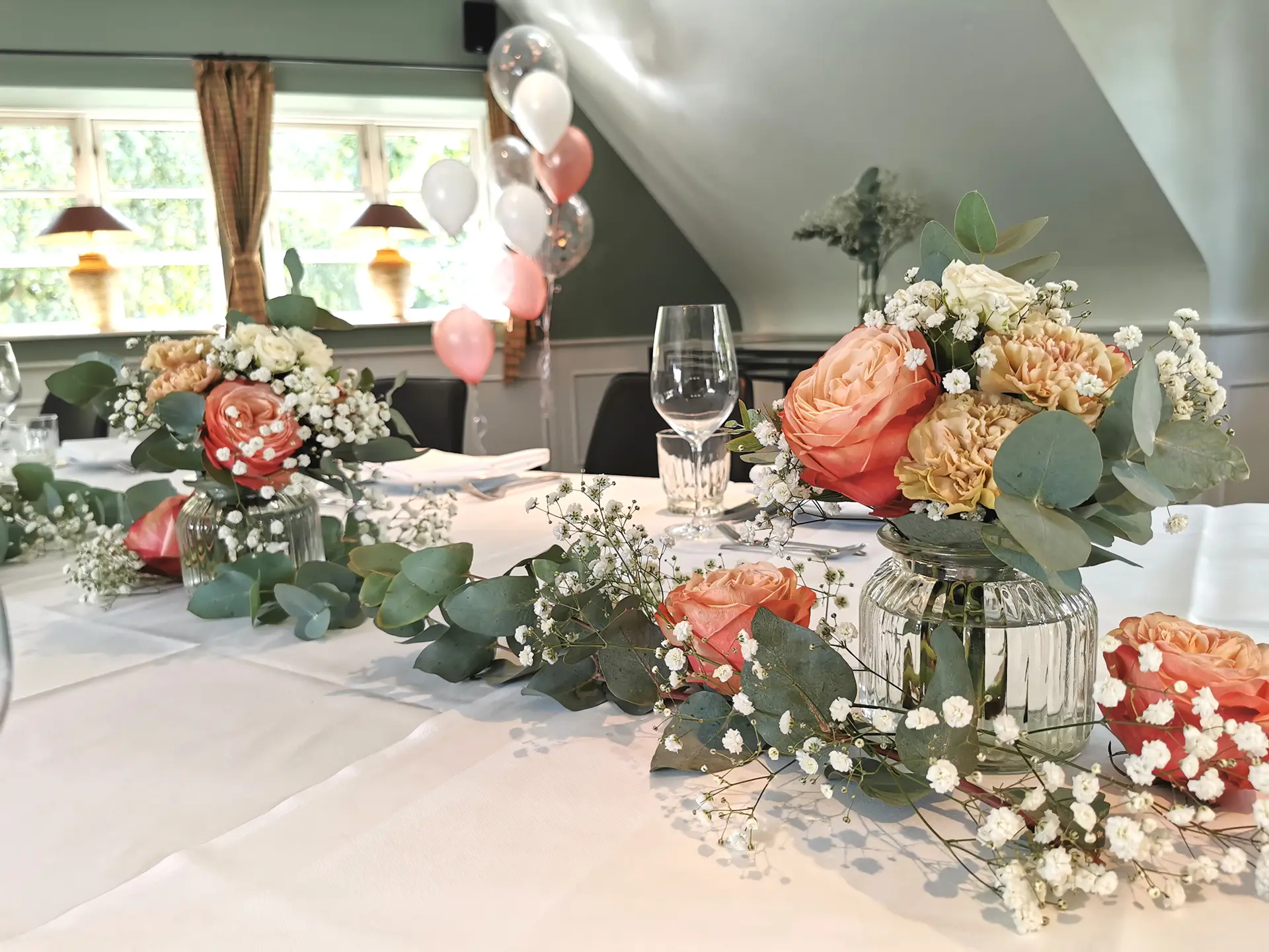 Weiße Rosen und Olivenzweige als Blumendekoration